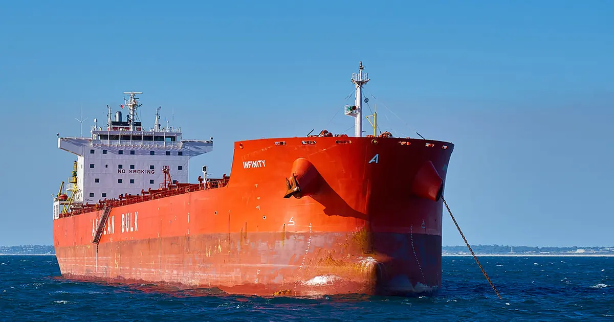 A red cargo ship at sea